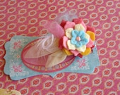 Flower hair clip pinks, yellows, and aqua blue flowers and leaves with feather.
