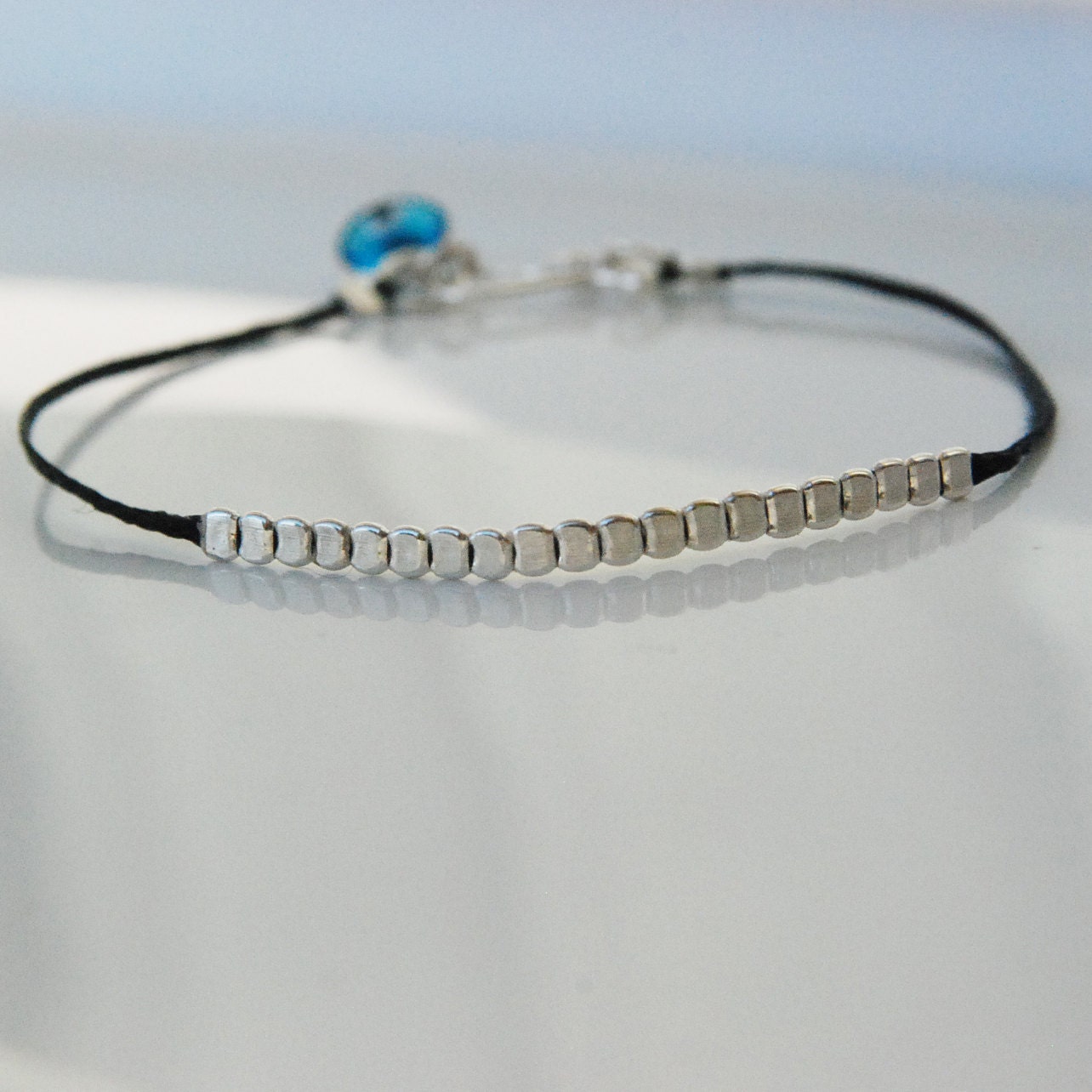 Simple bracelet with flat sterling silver beads and evil eye
