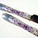 Elegant wedding cake serving set, hand decorated with purple fleur de lis pattern on a silver metal leaves background