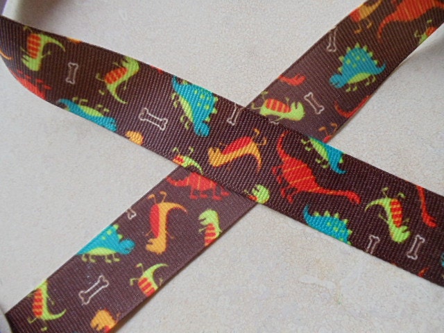 Multi colored prehistoric dinosaurs on brown 7/8 inch grosgrain ribbon