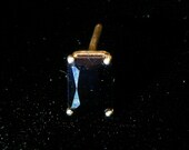 Dark blue sapphire tie tack in silver.