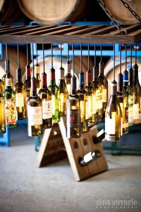 30 Wine Bottle Light Chandelier hanging from wood riddling rack