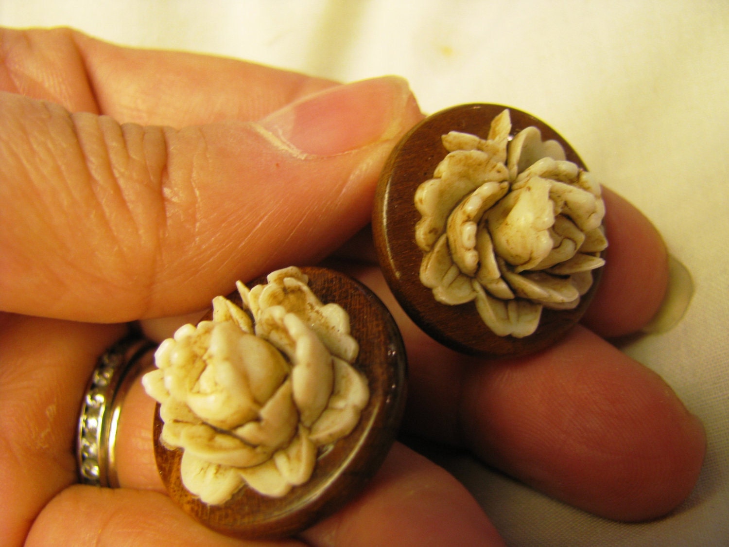 1940s  incredible bakelite or resin type wood look earings with white carved flowers. 1 inch clips