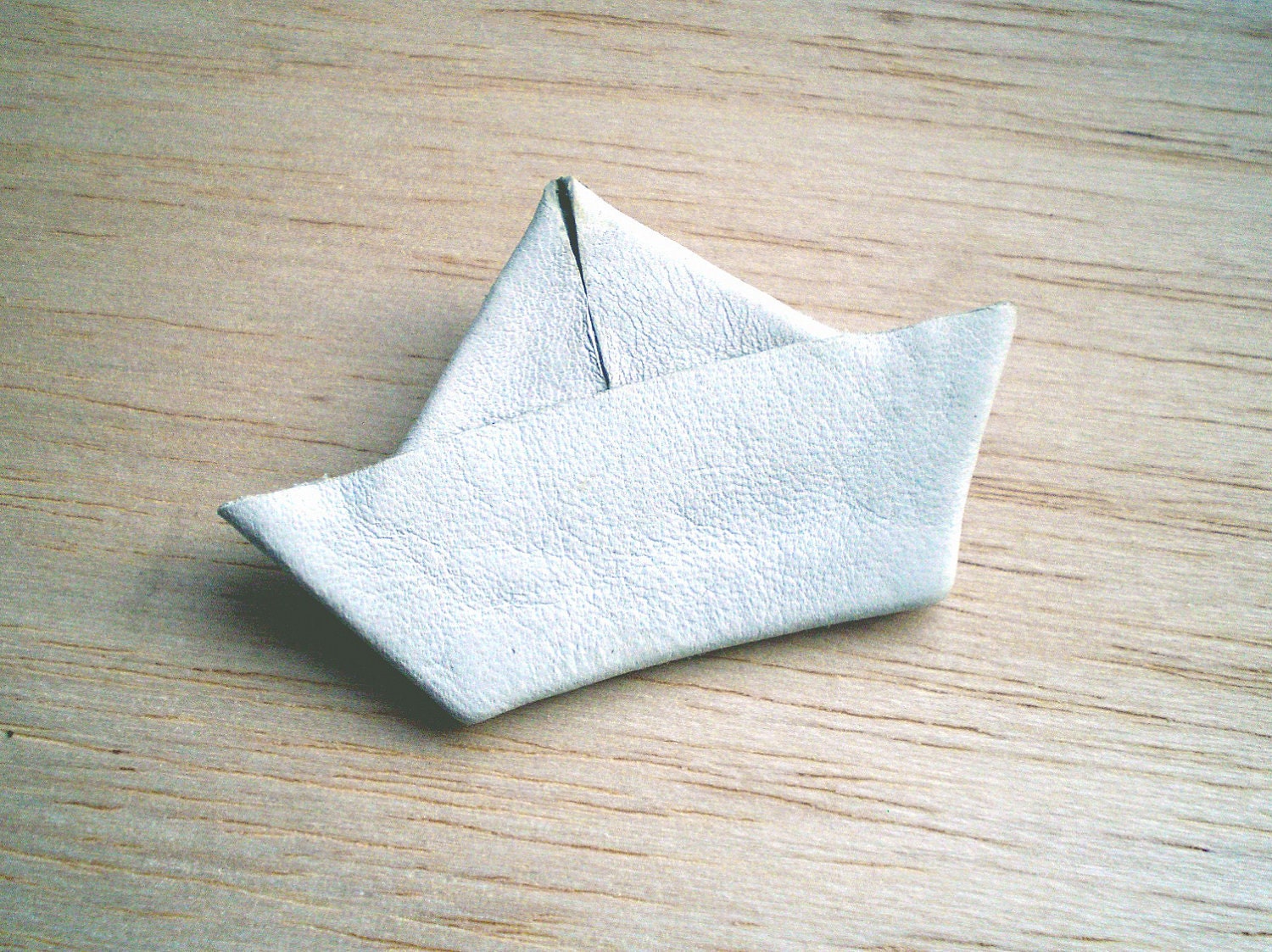 White paper boat pin, made of leather.