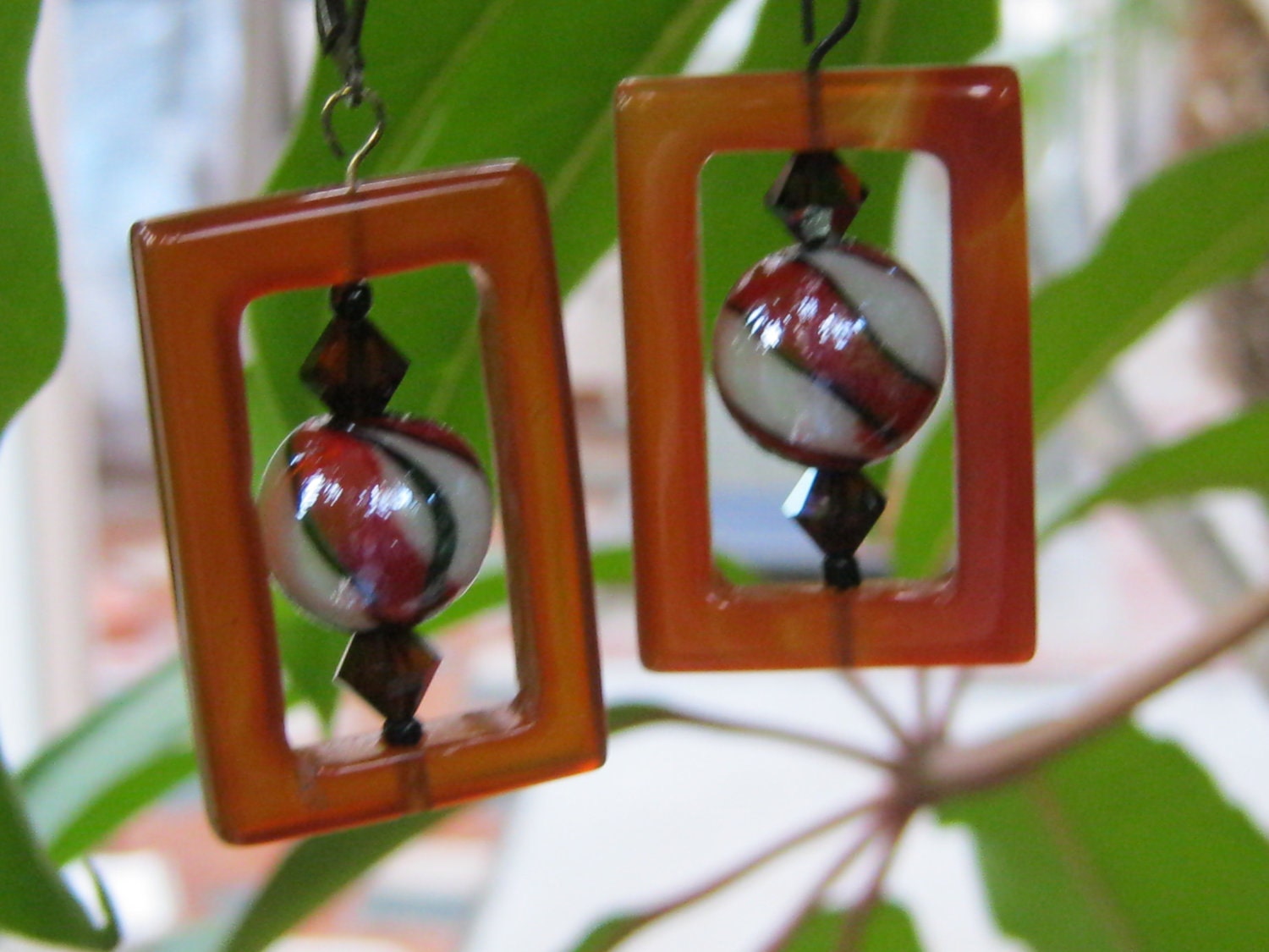 Dangle Earrings of hand carved red jasper frames glazed lampwork beads, with crystal bicone beads and antique gold ear wires.