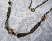 Brass Winged Choker with Champagne Faceted Glass Bead