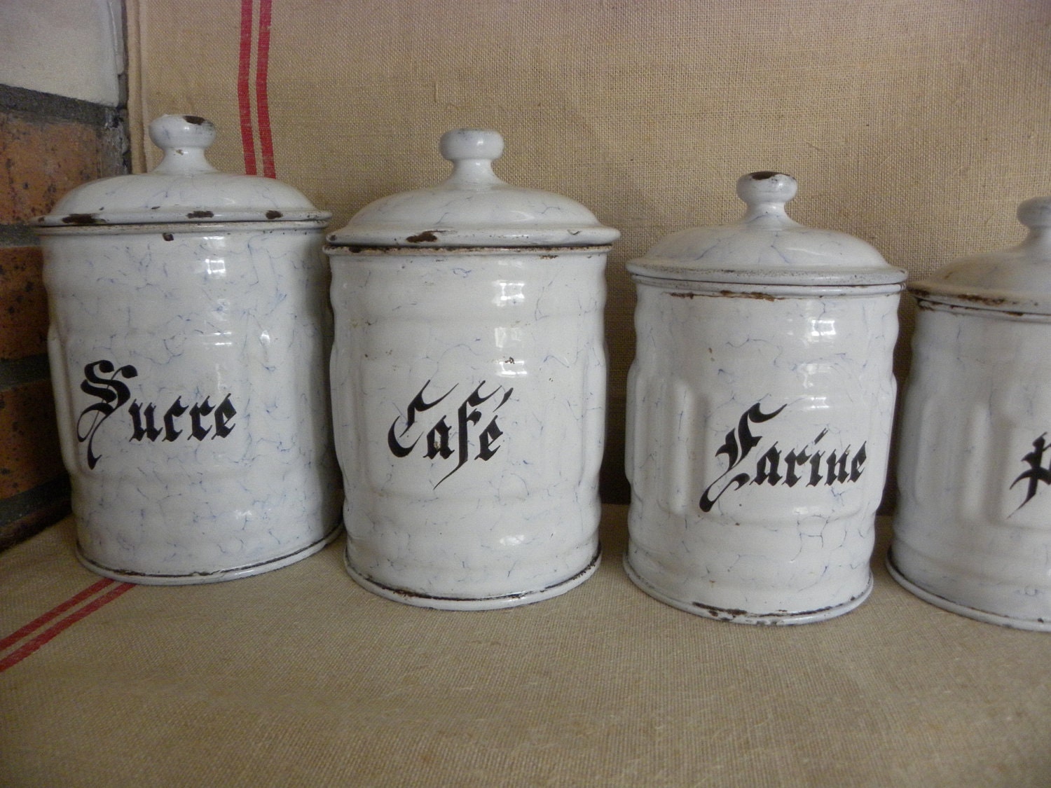 A serie of french white vintage enamel kitchen canisters. Cheaper shipping price in two parcels
