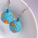 Turquoise crocheted dangle earrings orange embroidered branches and leaves ball earrings