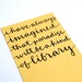 Yellow Bookmark with Handwritten Calligraphy . I Have Always Imagined That Paradise Will Be a Kind of Library