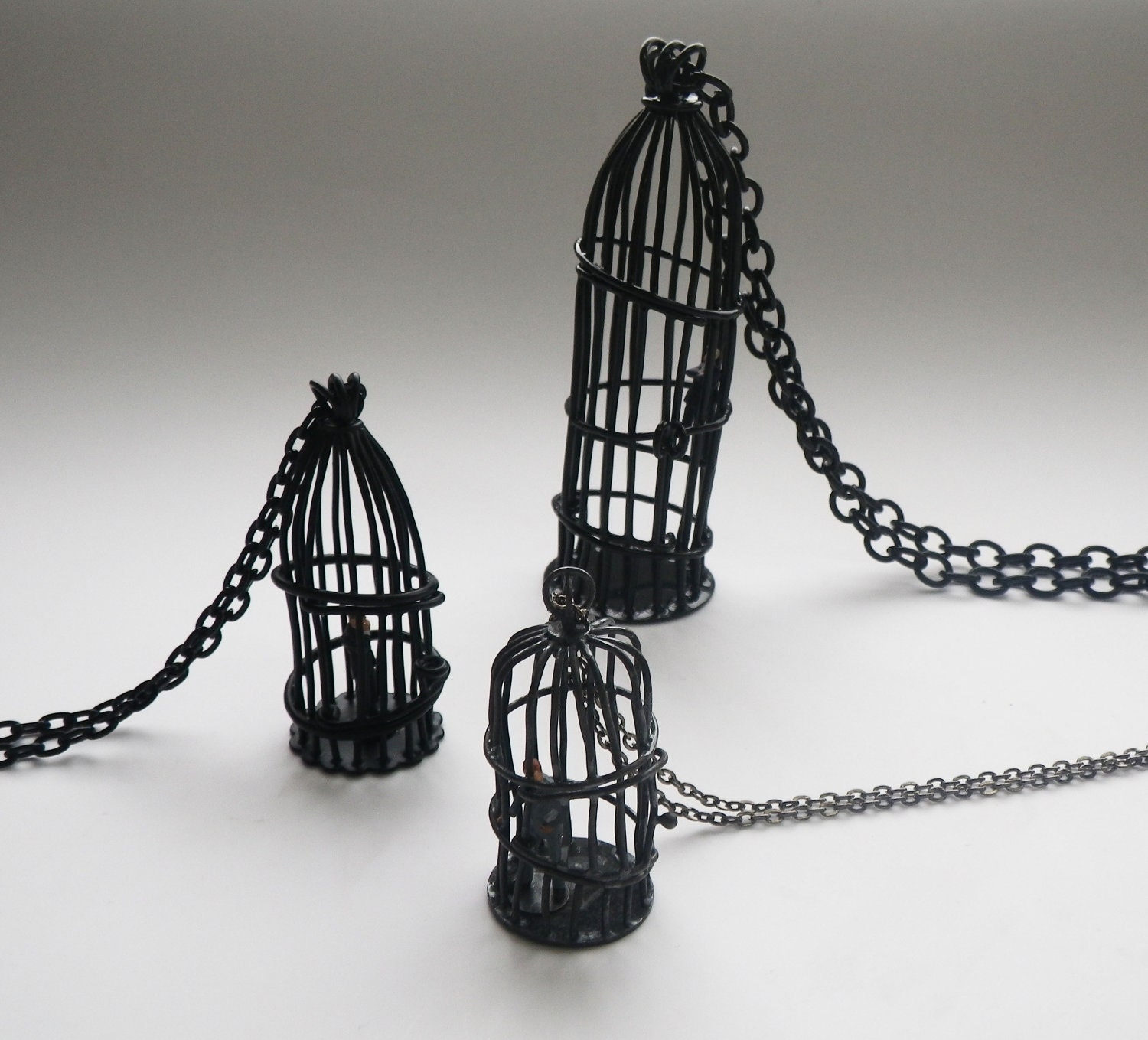 Bird cage pendant with tiny business man, matte black