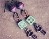 suri.  a pair of purple and teal rustic key earrings.