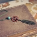 thea. a wood and brass feather necklace.