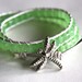 Leather wrap bracelet made with pearl colored leather, lime green cube crystals and silver dragonfly button clasp
