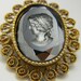 Black glass carved vintage cameo with ornate gold trim