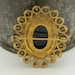 Black glass carved vintage cameo with ornate gold trim