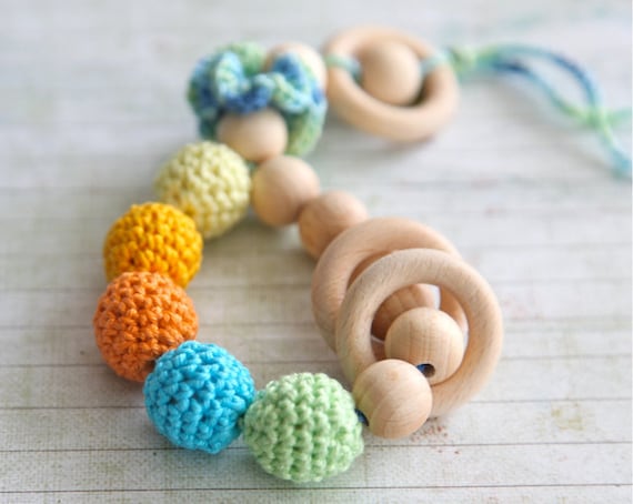 Teething toy rattle with crochet wooden beads and 3 wooden rings. Yellow, orange, light green, aqua blue/ cyan.