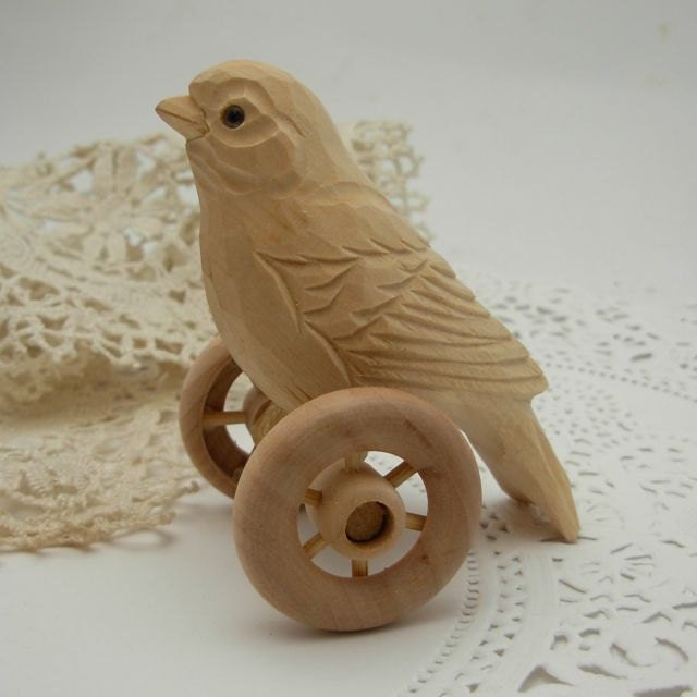 hand carved bird on wheels