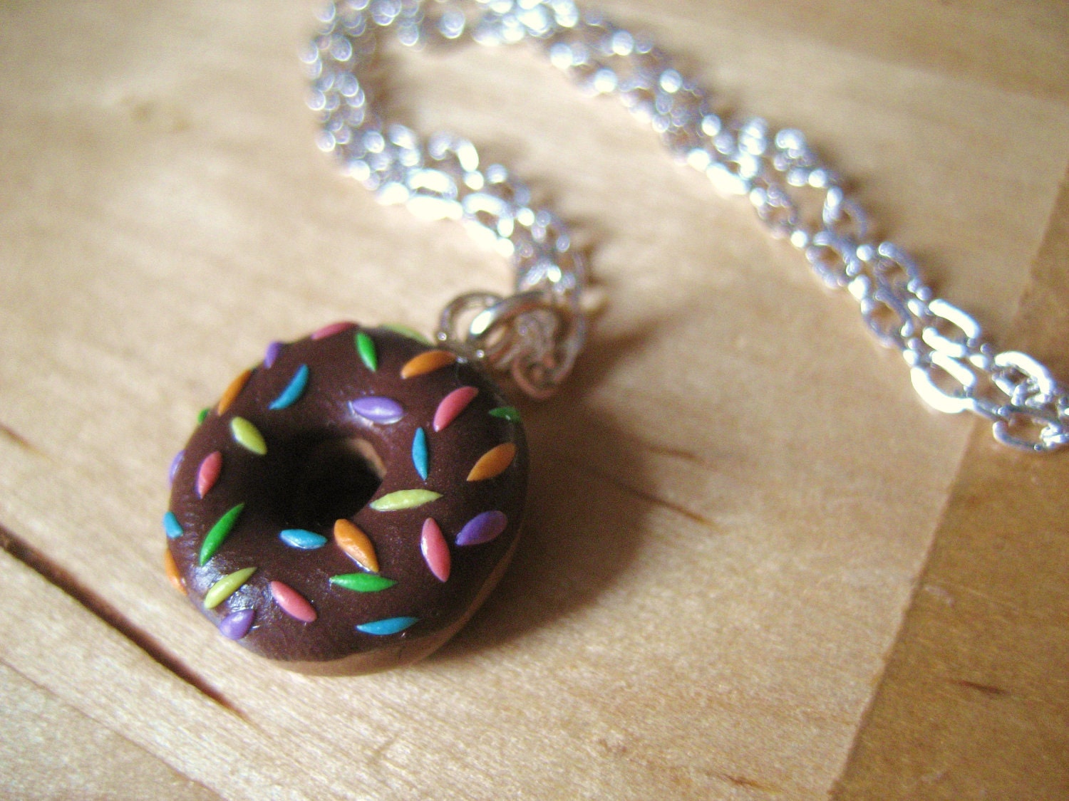 Rainbow-sprinkled donut pendant made from polymer clay