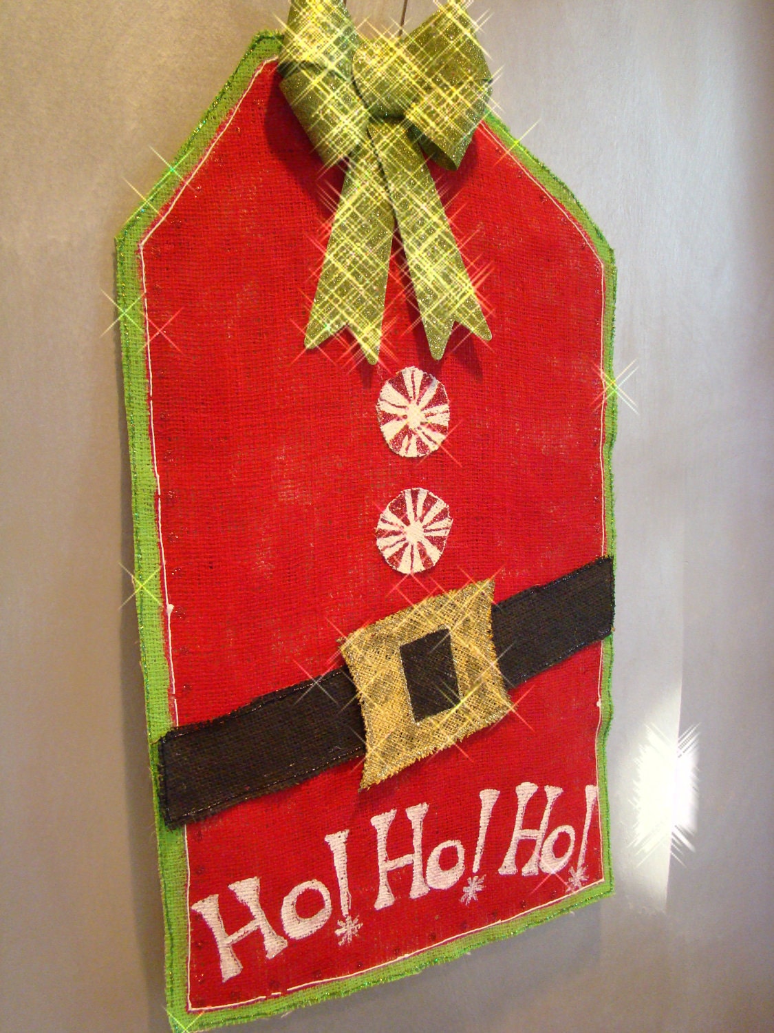 Santa gift tag hand painted burlap door/wall hanging in christmas red and embellished with burlap belt, candy buttons and glitter bow