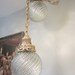 Pair of vintage 70's brass and glass swag hanging globe light fixtures