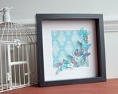 Turquoise fluttering butterflies in black box frame