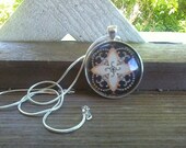Black, cream and peach patterned pendant with silver necklace