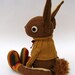 Woollen Rabbit - Handmade plush sculpture - brown woollen body with flesh coloured felt ears - wearing mustard woolly pullover.