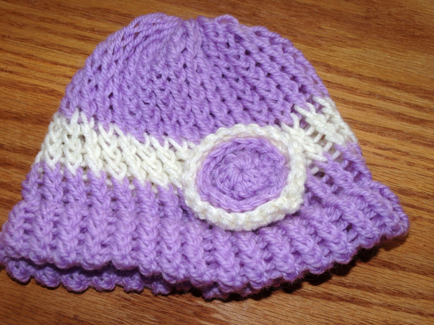 purple and cream crocheted baby hat with circle detail