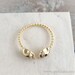 tiny gold skull heads ring