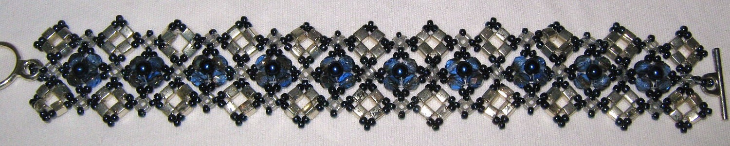 Art Deco sliver and navy blue right angle weave bracelet featuring fire polished rounds, glass pearls, and silver cube beads