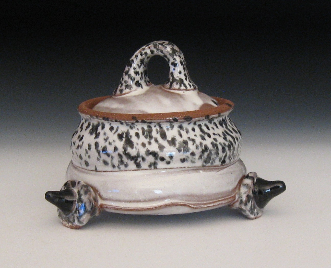 black and white spotted lidded jar with spike feet
