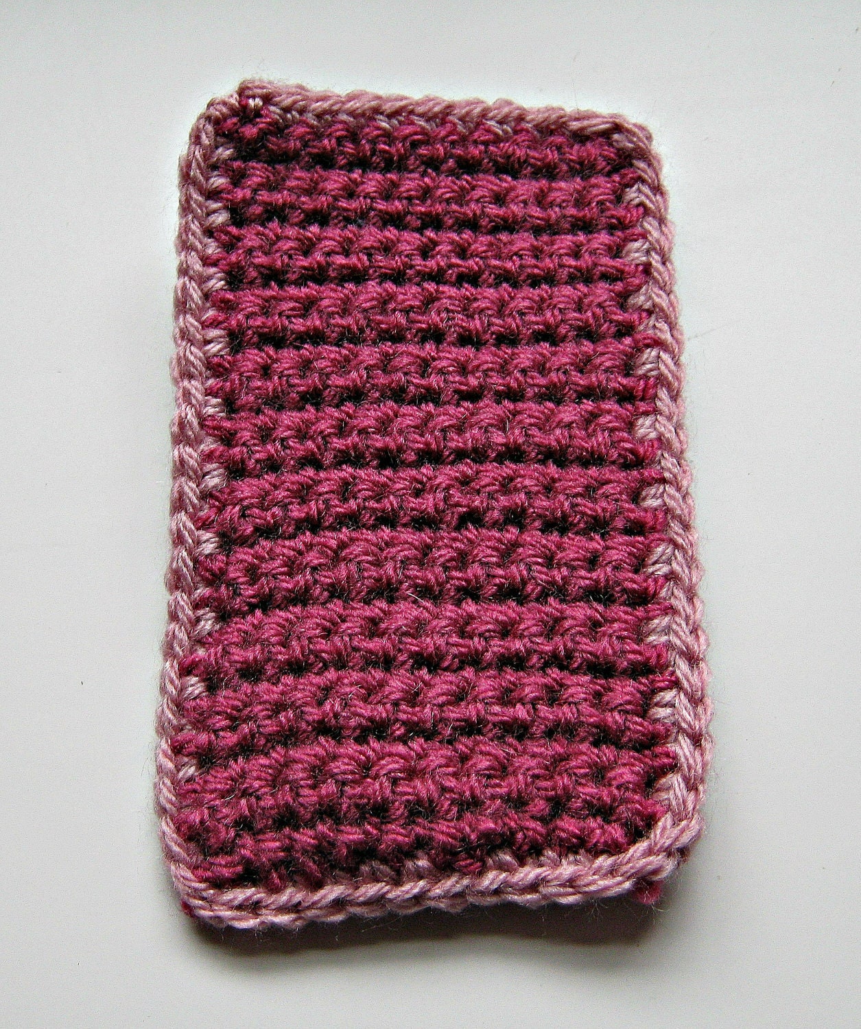 Crocheted iPod cover in dark pink with a pale pink trim