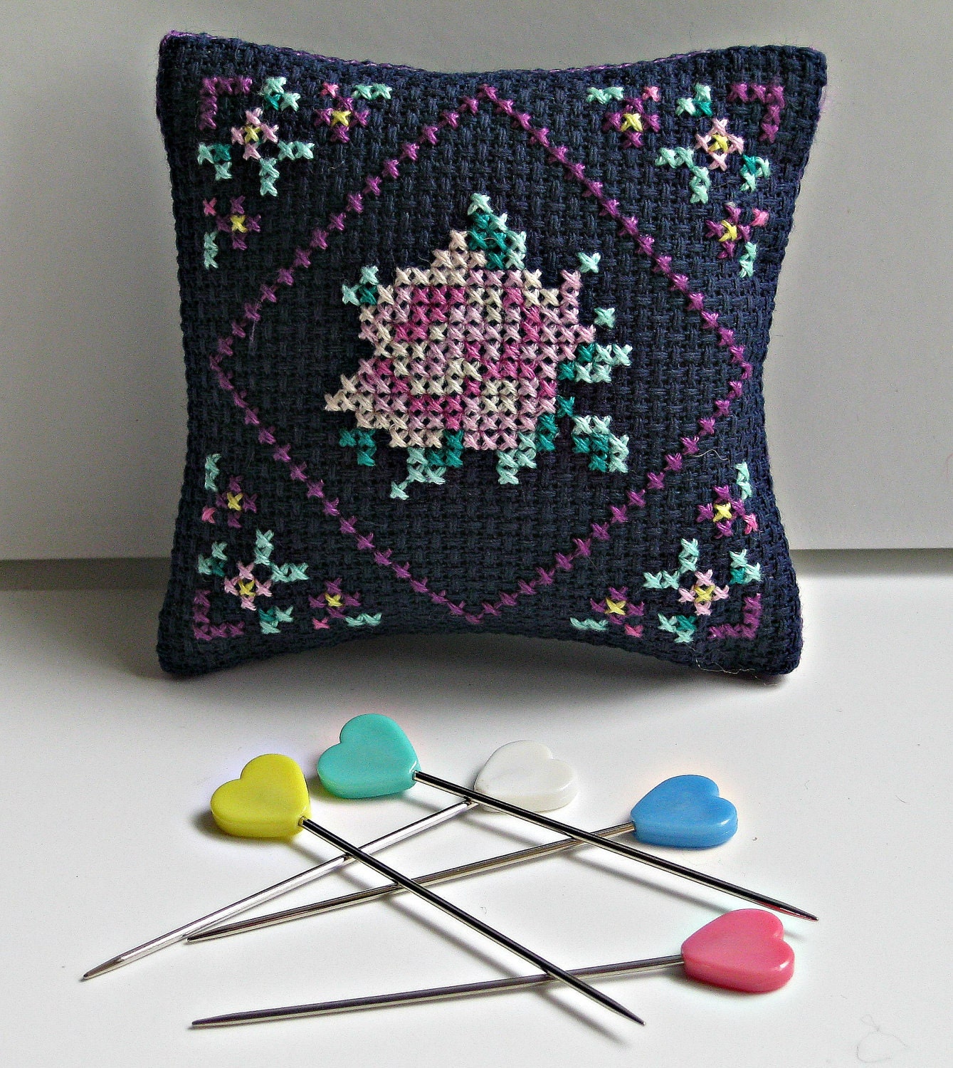 Pincushion with a cross stitched rose design