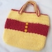 Crocheted tote bag of red and yellow cotton yarn with yellow button accents