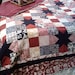 Queen size Sawtooth Star quilt in rich red, black, and creams.