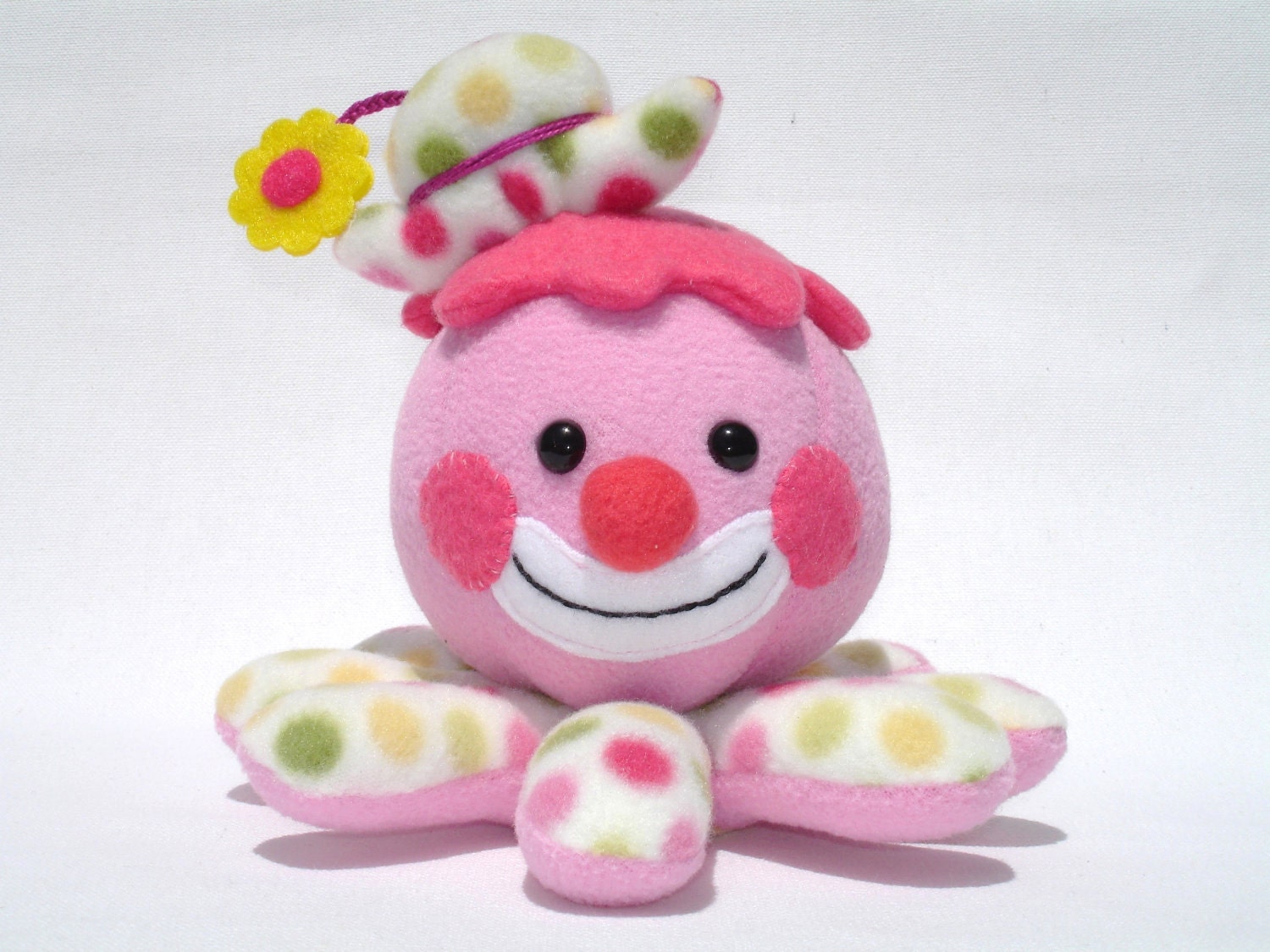 Stuffed octopus clown toy with pink polka dots and flower hat