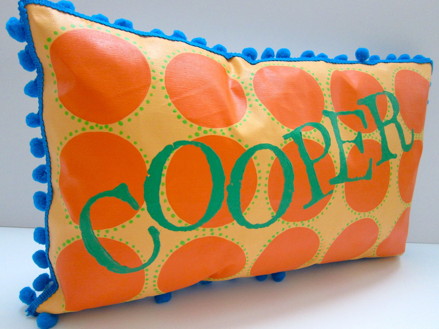 Baby pillow in orange and bright green. Personalized with name.