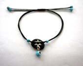 bracelet with beach pebble and sterling silver steering  wheel and an" evil eye" glassbead...adjustable