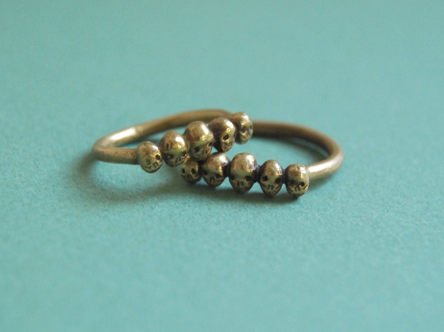 Golden row of tiny skulls ring