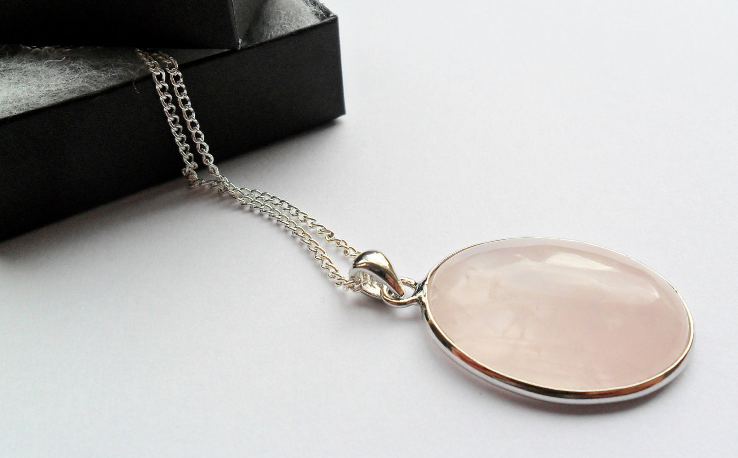 Oval rose quartz pendant on long silver chain