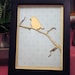 Laser cut bird on a branch with vintage wallpaper in a black frame