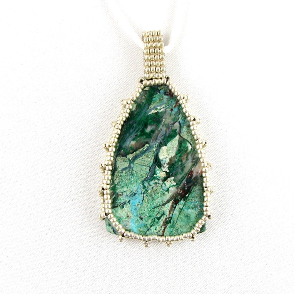 Turquoise in Moss Agate caged in Silver