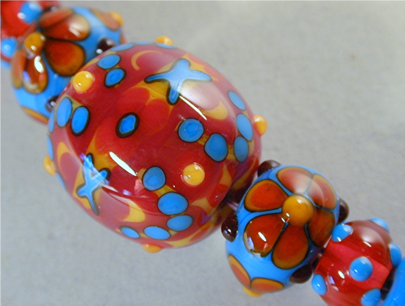 Handmade Lampworked Glass Bead Set of 7, ooak by Patti Cahill, sra -- Swimsuit colors with X's and O's fancy focal