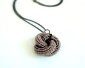 Eternally. Crochet knot pendant in sand.