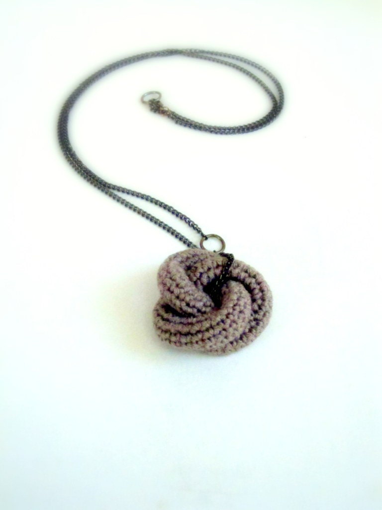 Eternally. Crochet knot pendant in sand.