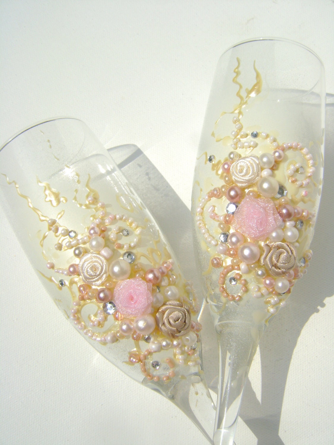 Beautiful wedding champagne glasses in light pink, ivory and champagne, with a touch of silver crystals