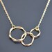 Modern swirl triple ring gold necklace