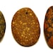 three mottled stones, drilled beach rocks with inclusions