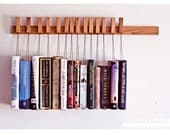 Custom made wooden book rack in Oak. Pins also work as bookmarks.