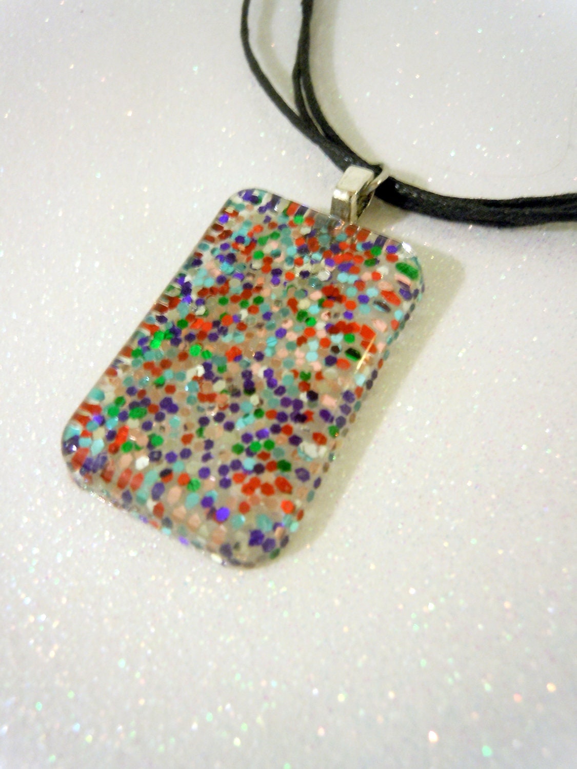Multi-color glitter charm on black cord necklace